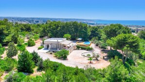 A modern house with a pool, surrounded by dense greenery and a clear view of the sea. - Sea view pool villa w/ garden, 2km from sand (Torre Pali)