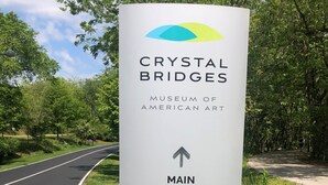 Schild für das Crystal Bridges Museum der amerikanischen Kunst mit einem Pfeil, der zum Haupteingang weist.