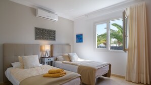A hotel room with two beds, a nightstand, a lamp, and a window with curtains. - Private villa with pool and whirlpool in a quiet location (Puerto del Carmen)