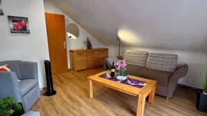 Un salon moderne avec un canapé gris, une table basse en bois et un canapé marron.