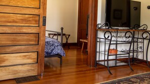 A room with a wooden sliding door, a TV on a stand, a patterned rug, and a small table with chairs. - Residence on the Roundabout (St Charles)