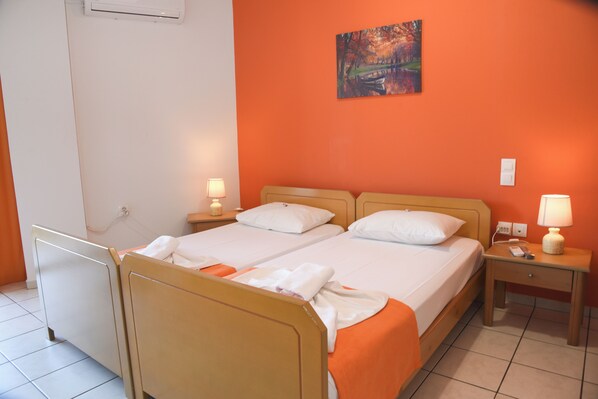Ein Hotelzimmer mit zwei Betten, einem Bild an der Wand und einem Nachttisch mit Lampe.