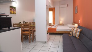 A compact room with a kitchenette, a dining area, a bed with a nightstand, and a sofa. - Economic Studios  B3 (HERAKLION CRETE)