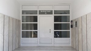 A white double door with a sign above it. - Economic Studios  B3 (HERAKLION CRETE)