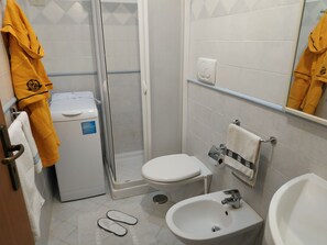 Een douche, een haardroger, een bidet, handdoeken
