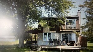 A two-story house with a deck, large windows, and a chimney. - Lake Ontario: Henderson, NY (Henderson)