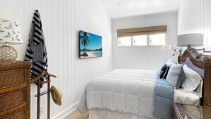 Ein Schlafzimmer mit Bett, einem Bild, einem Fenster und einer Lampe.