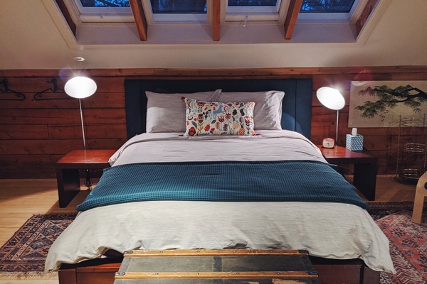 A dreamy bed with a view into the trees.