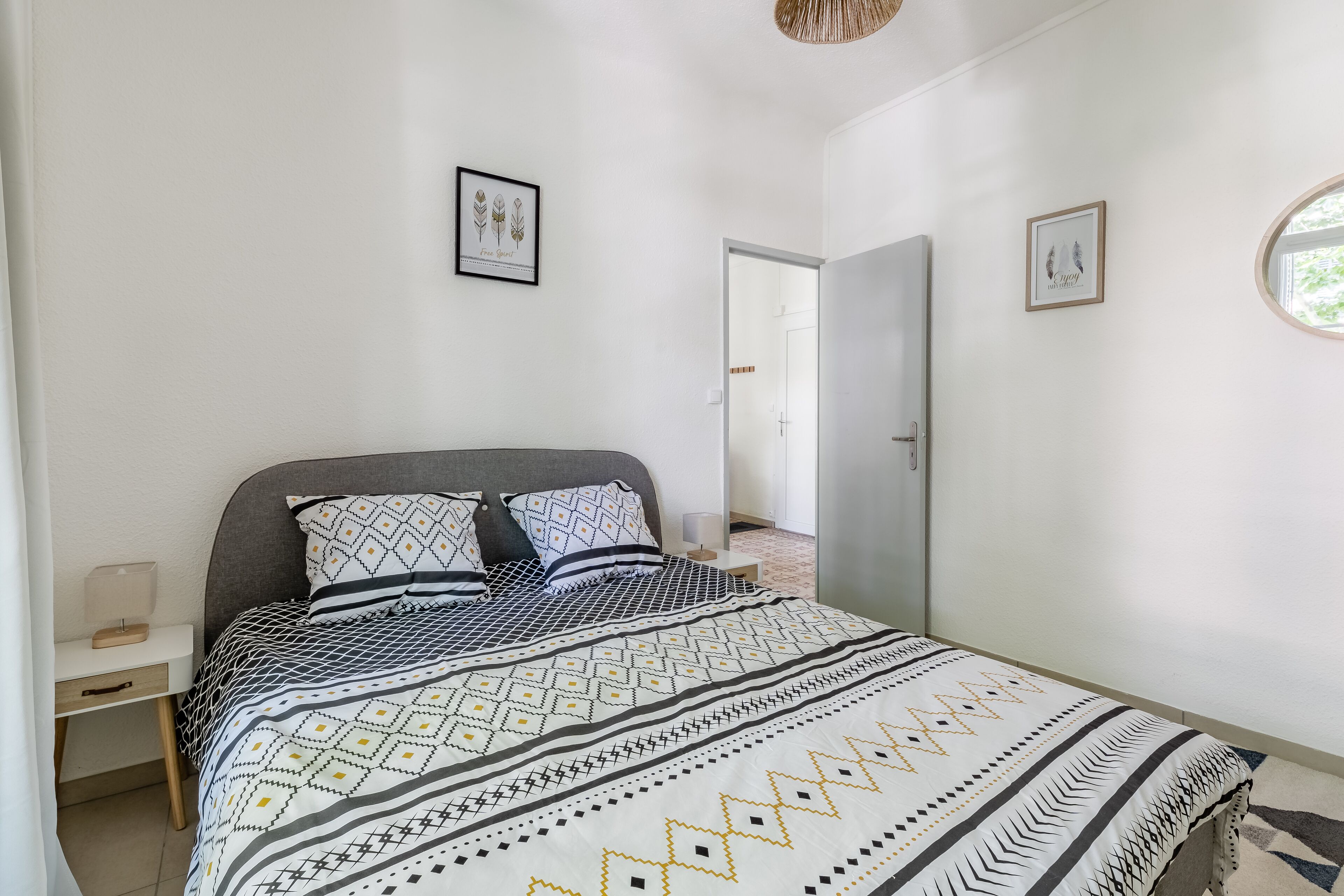 A bedroom with a bed, bedside tables, and a wardrobe.