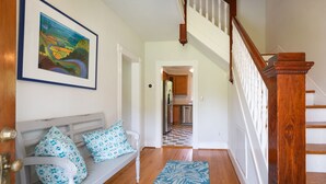 A hallway with a wooden bench, a patterned rug, and a staircase with a wooden railing. - Irvington Country Getaway House (Irvington)