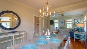 A dining area with a large round table, blue placemats, and a chandelier. - Irvington Country Getaway House (Irvington)