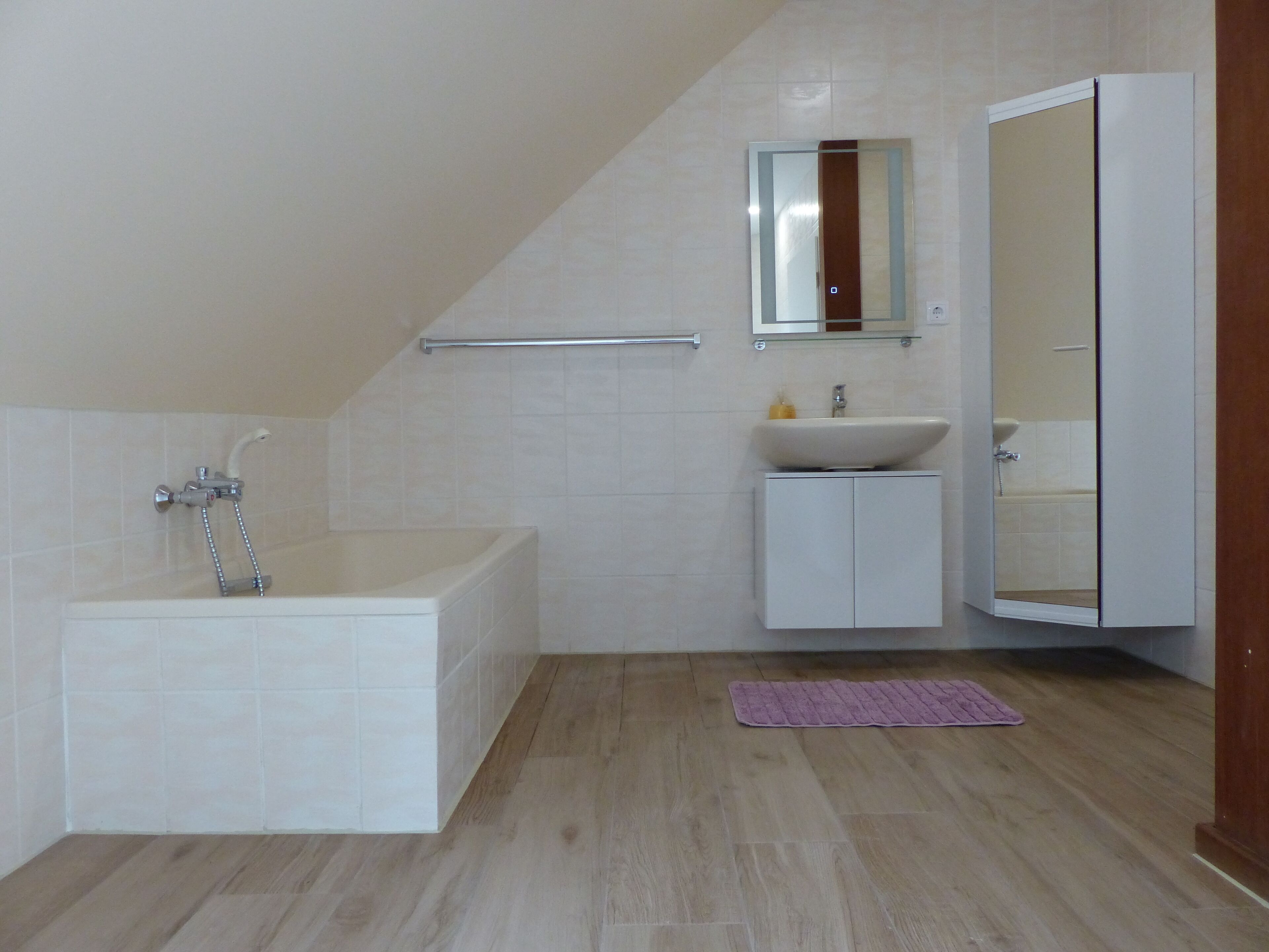 Une salle de bain moderne avec une baignoire, un lavabo et un miroir.