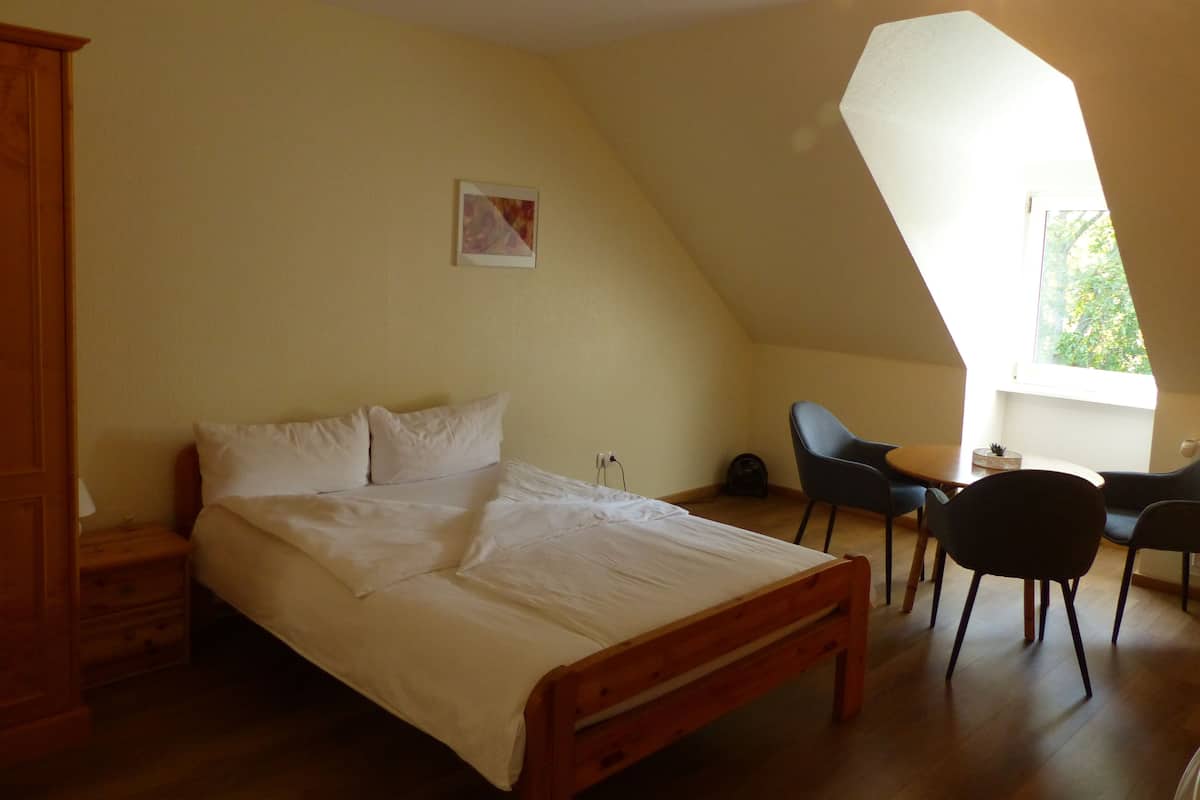 Ein Schlafzimmer mit Bett, Schreibtisch und Stuhl.