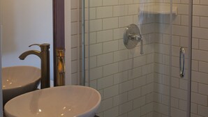 A bathroom with a glass shower enclosure, a sink, and a framed picture on the wall. - Artistic Lodging Queen suite (Paris)