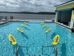 A swimming pool with lane markers and a view of the lake.