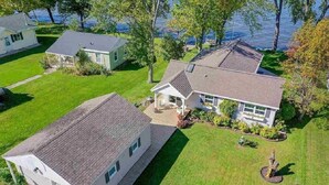 A residential area with a house featuring a front porch, a swimming pool, and a view of a lake. - WATERFRONT DOOR COUNTY HOME.  Gorgeous Sunsets. 3 Bedrooms. Sleeps 6.   5 star! (Door County)