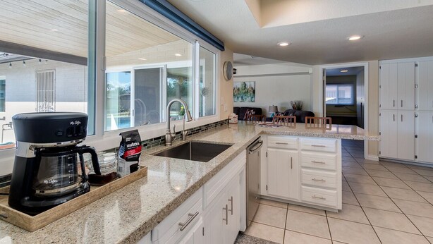 A modern kitchen with a large island, a coffee maker, and a sink. - PET FRIENDLY IN QUIET NEIGHBORHOOD! (Tempe)