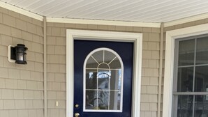 A dark blue door with a white frame and a small window above it.