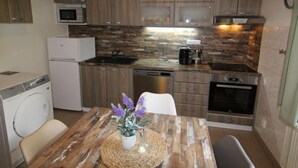 A compact kitchen with wooden cabinets, a microwave, a coffee maker, and a dishwasher. - Holiday Hill 26 by Interhome (Cerny Dul/Cista)
