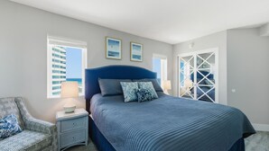 Un dormitorio con cama, mesita de noche, una silla y ventana con persianas.