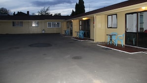 A motel with a covered parking area, outdoor seating, and a single-story structure. - Taihape Motel (Taihape)