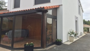 Een modern huis met een glazen patio, een houten interieur en een pannendak.