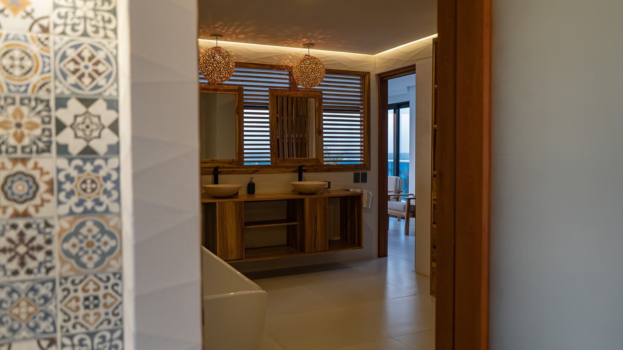 Un bagno moderno con un mobile bagno in legno, due lavandini e uno specchio grande.