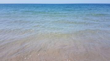 Una playa con agua cristalina y orilla arenosa.