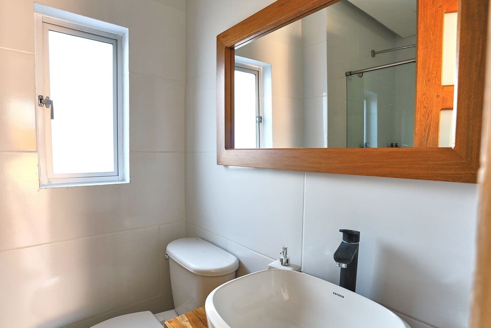 A bathroom with a toilet, a sink, and a window.
