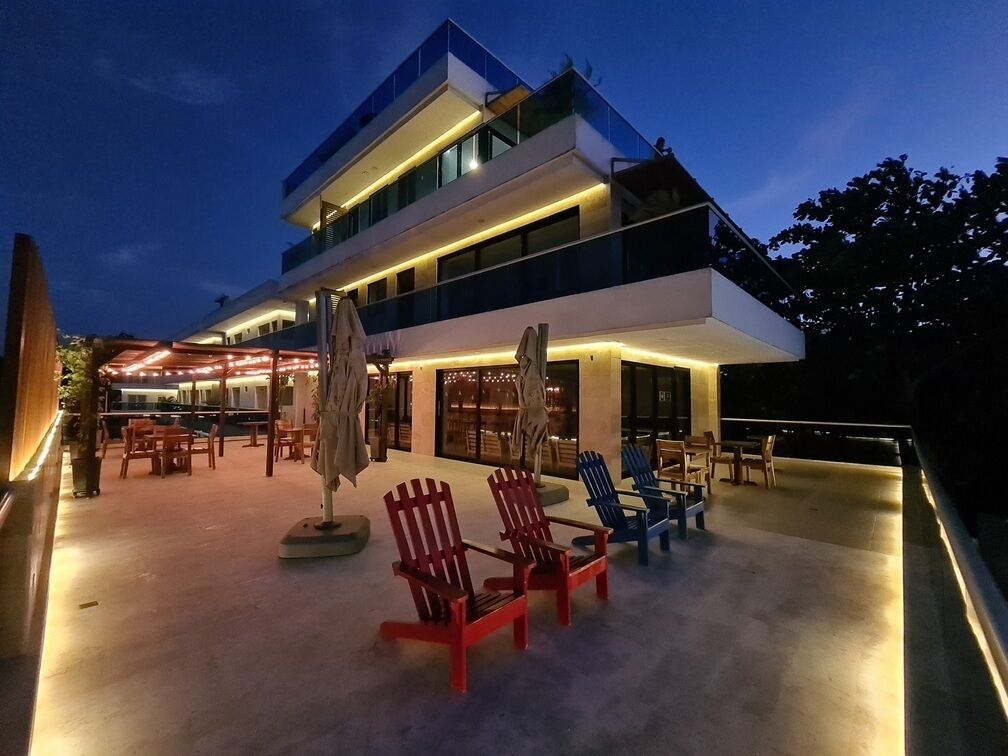 Un edificio moderno de varios pisos con terraza al aire libre y una estatua.