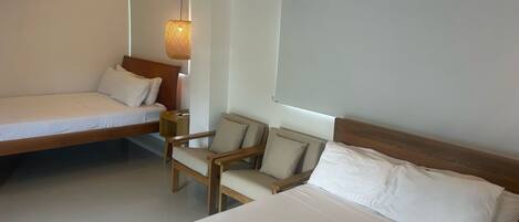 A modern hotel room with a bed, a chair, and a small table.