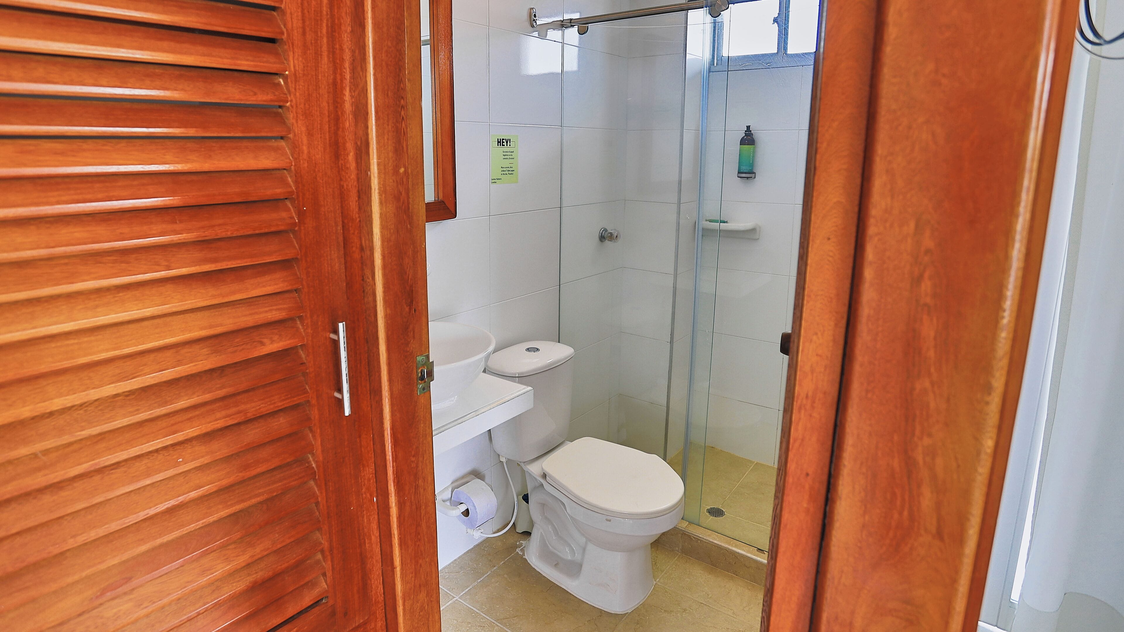 A bathroom with a toilet, sink, and shower.