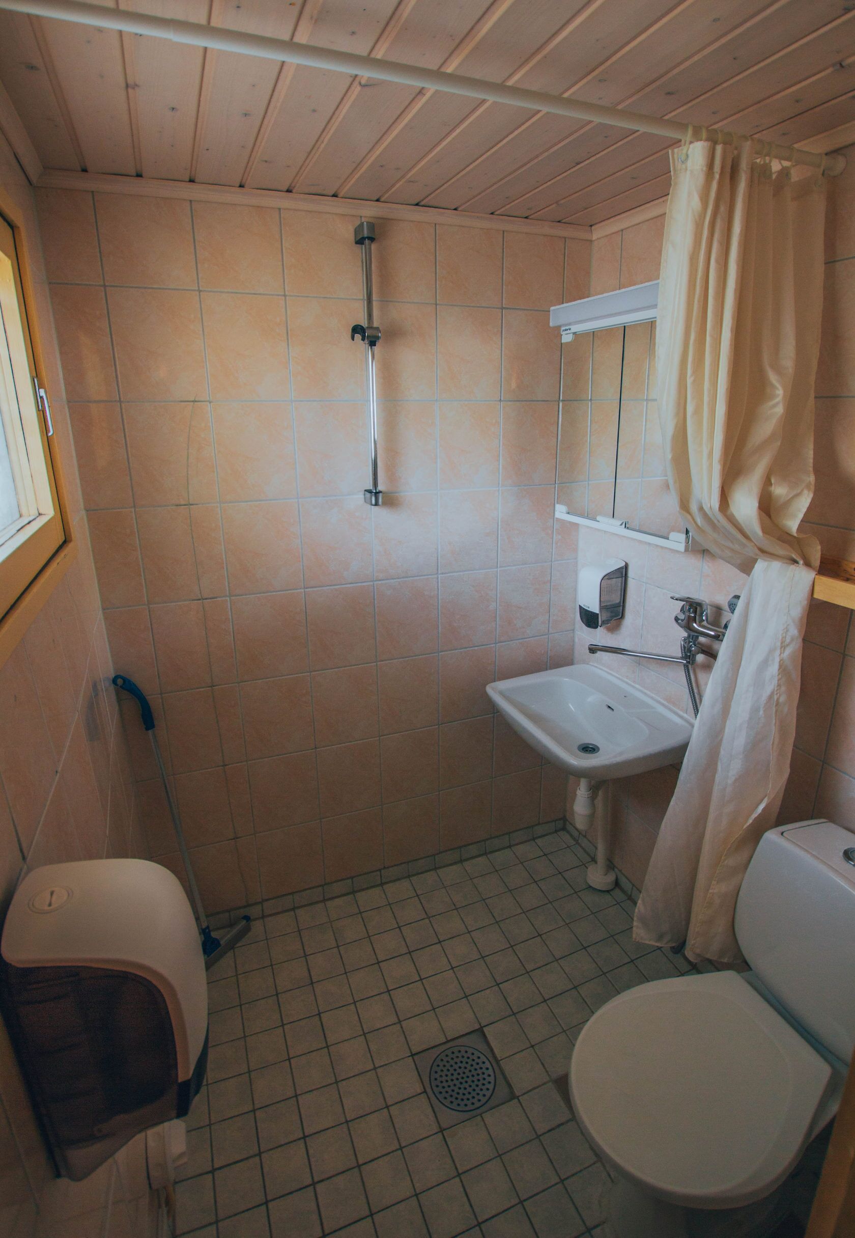 Ein kleines Badezimmer mit Toilette, Waschbecken und Dusche.
