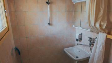 Ein kleines Badezimmer mit Toilette, Waschbecken und Dusche.