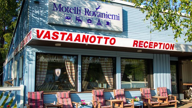 Un motel con zona de recepción y mobiliario exterior.