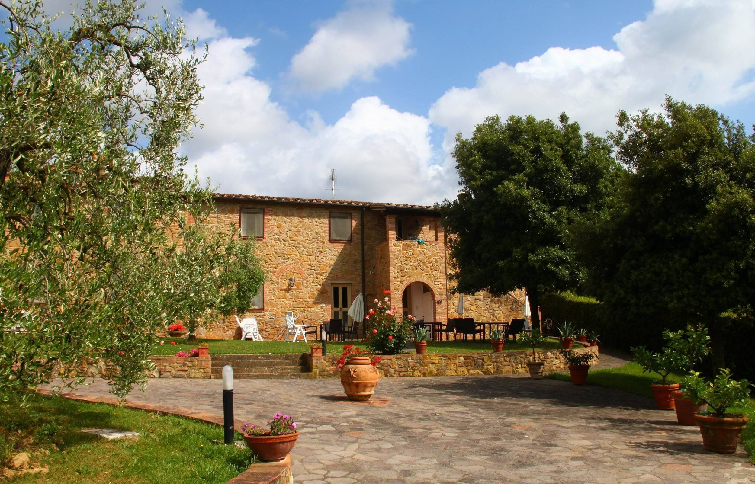 A stone building with a courtyard, outdoor seating, and potted plants.