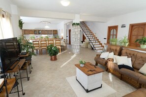 Relax in this stylish living area with a large flat-screen TV, comfortable sofa, and dining table.