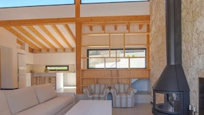 A modern living room with a sofa, a table, and a fireplace. - Casa Bio Nueva: Super sea views, heated pool, 100MB wifi, A / C (Jávea)