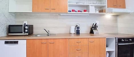 A modern kitchen with wooden cabinets, a microwave, a coffee maker, and a dishwasher.