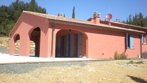 A building with a red facade, arched doorways, and a satellite dish on the roof. - Villa for groups and families, with Private Pool in Monteverdi Marittimo (Monteverdi Marittimo)