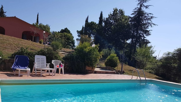 A swimming pool with lounge chairs and inflatable rings. - Villa for groups and families, with Private Pool in Monteverdi Marittimo (Monteverdi Marittimo)