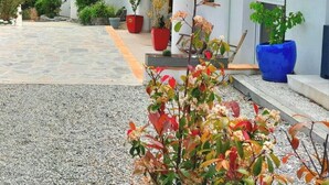 A white building with a tiled roof, a stone-paved entrance, and potted plants. - Maxima Sunset WAIKIKI 4 pers (Sainte-Maxime)
