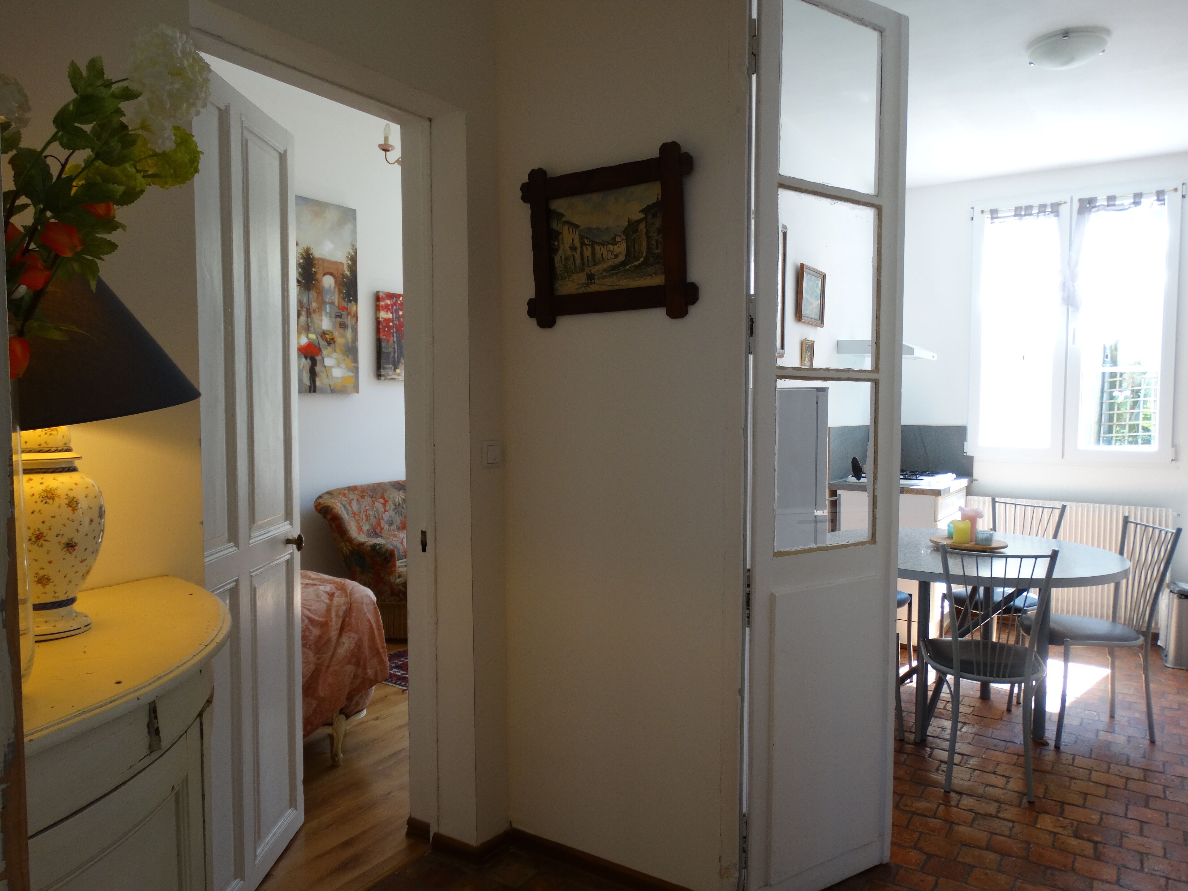 A room with a bed, a chair, a table, and a window.