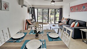 Een eetgedeelte met een houten tafel voor vier personen, een bank en uitzicht op het omliggende landschap.