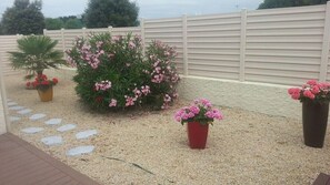 Stroll through the serene garden, surrounded by vibrant potted plants and a meandering gravel pathway.