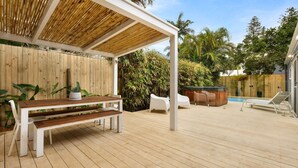A wooden deck with a covered seating area, a hot tub, and a pool. - Aaloka Bay - heritage charm w. pool & spa (Byron Bay)