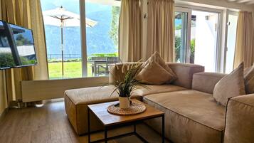 A living room with a sofa, a coffee table, and a TV.