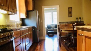 Une cuisine avec des meubles de rangement en bois, un réfrigérateur et une cuisinière.