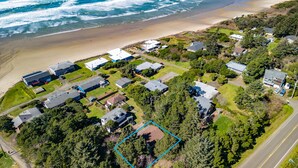 Oversigtsbillede af et kystnært boligområde med huse, en strand og en vej.