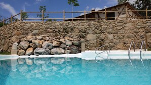 A stone wall with a pool in front. - Hotel Rural San Giles (Aldeanueva de la Vera)